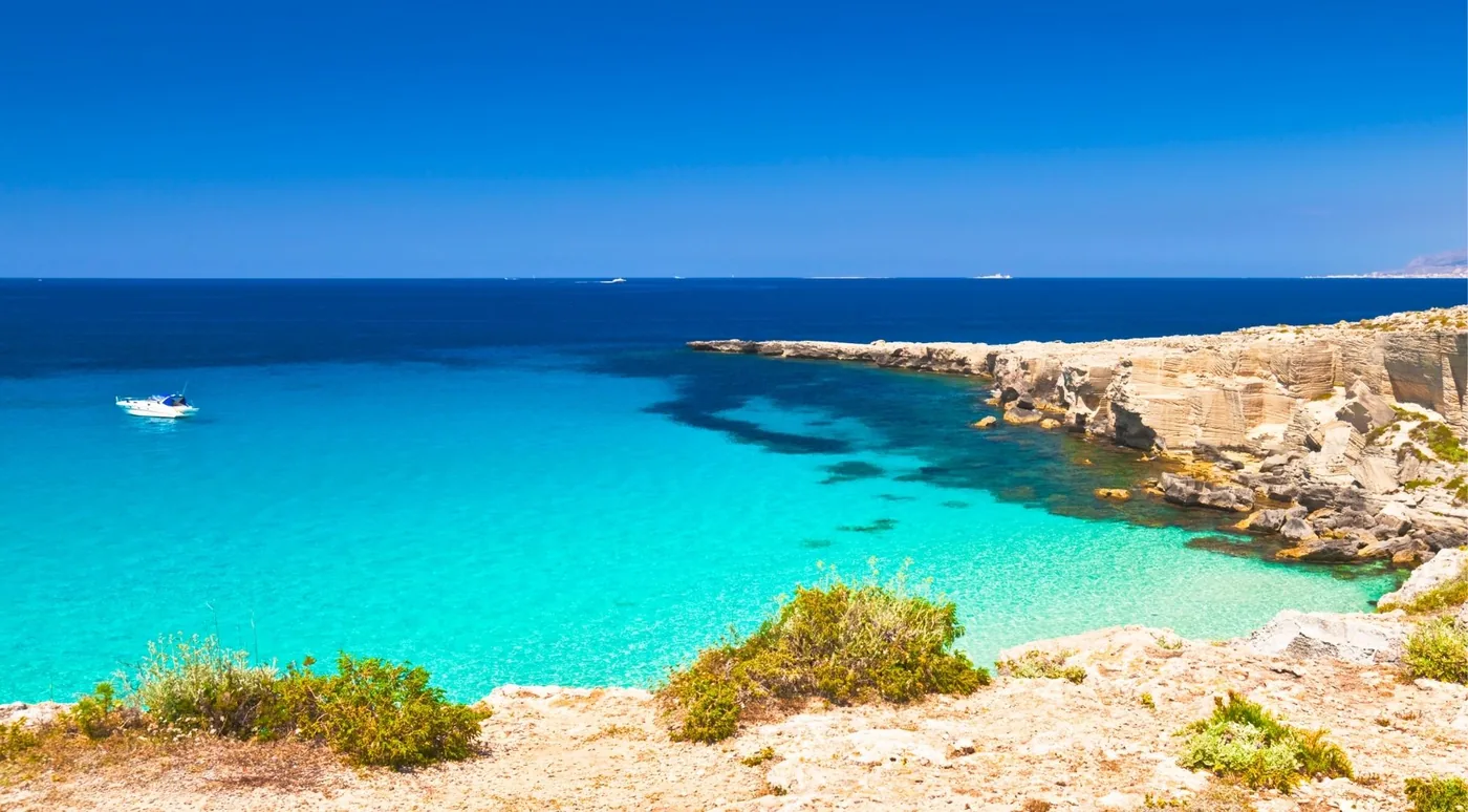 A wide turquoise cove on the Favignana coastline seen from above