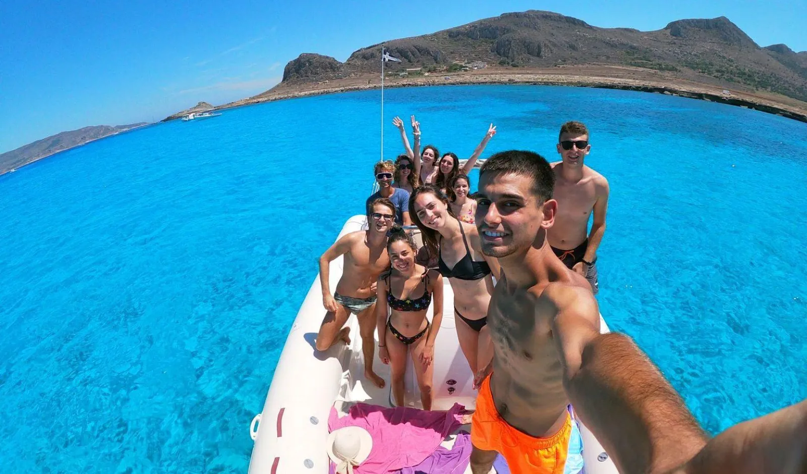 Guests on the RIB's bow with the Favignana headland behind