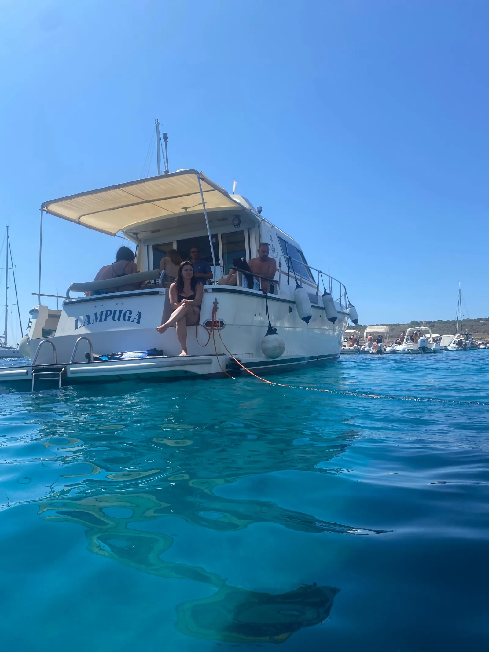 The excursion boat at anchor in clear water off the island coast