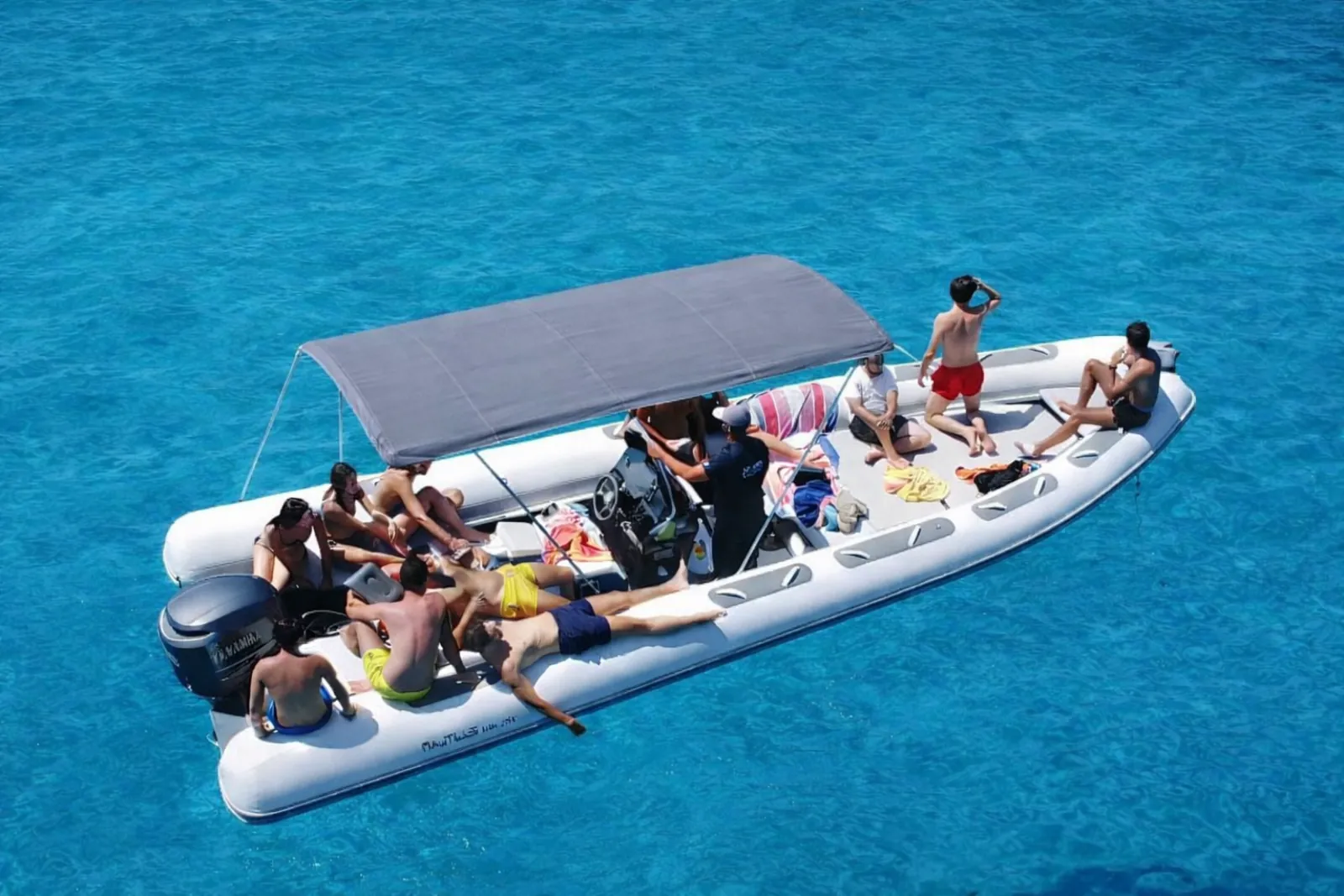 Guests seated under the RIB's sun canopy at a swim stop