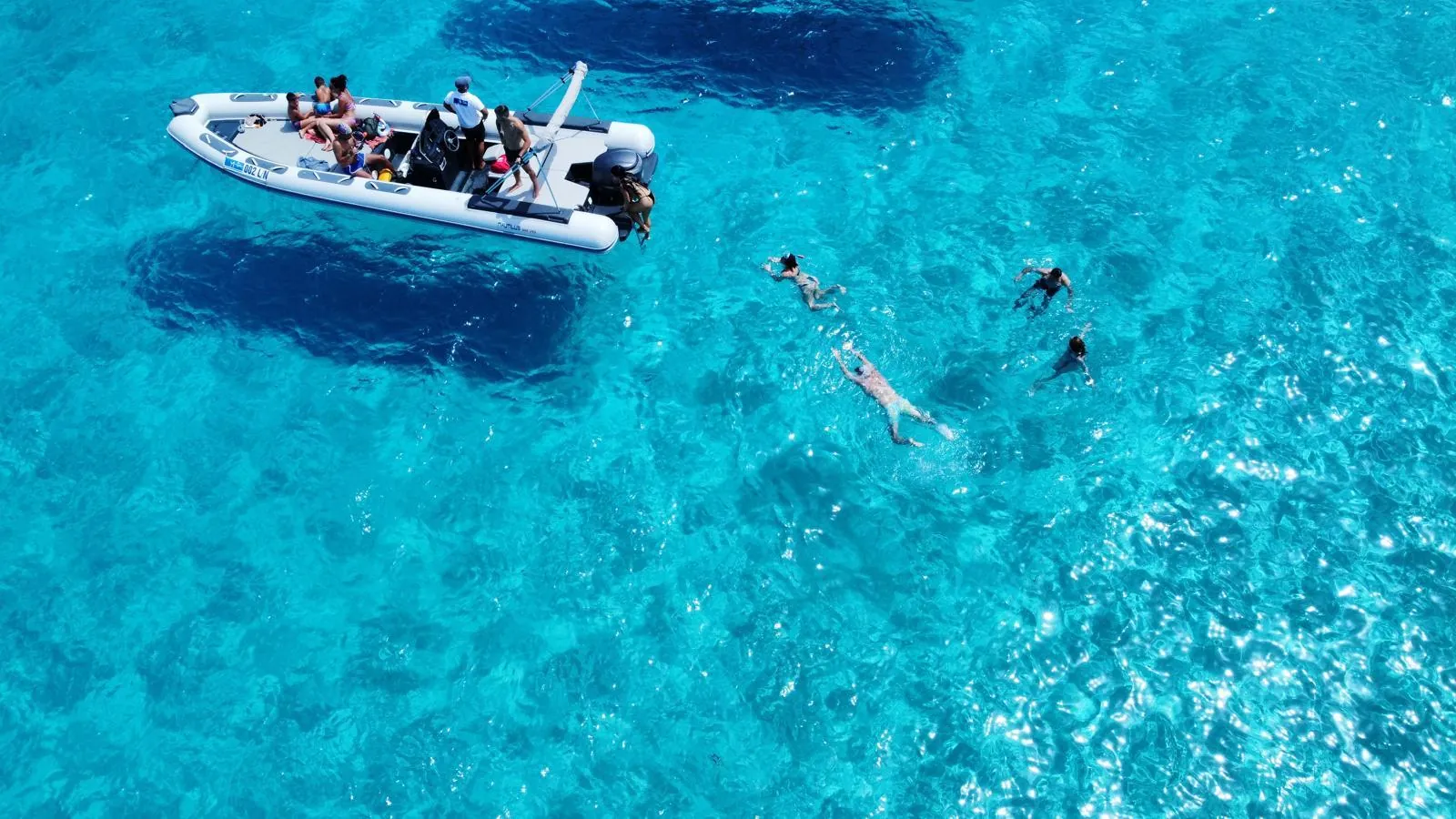 The RIB at anchor with snorkellers in the water alongside it