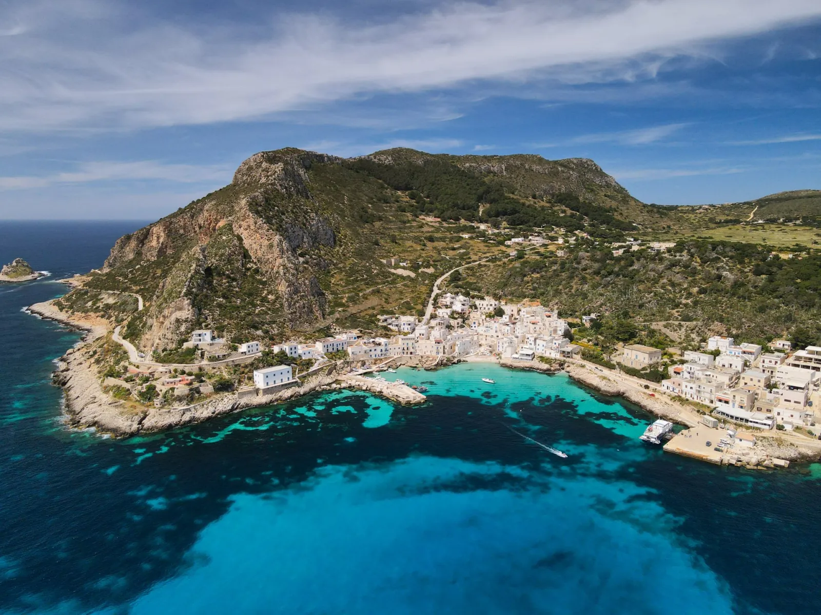 Levanzo village and its harbour at Cala Dogana seen from the air below the headland