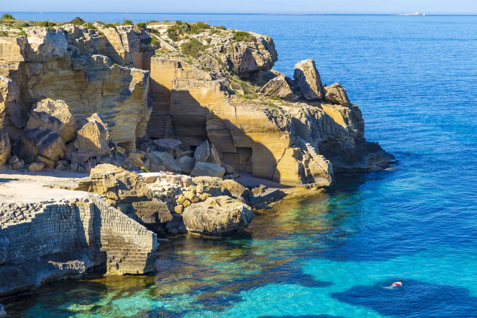 Cut tuff cliffs and a narrow inlet on the Favignana coast, typical of the Bue Marino stretch