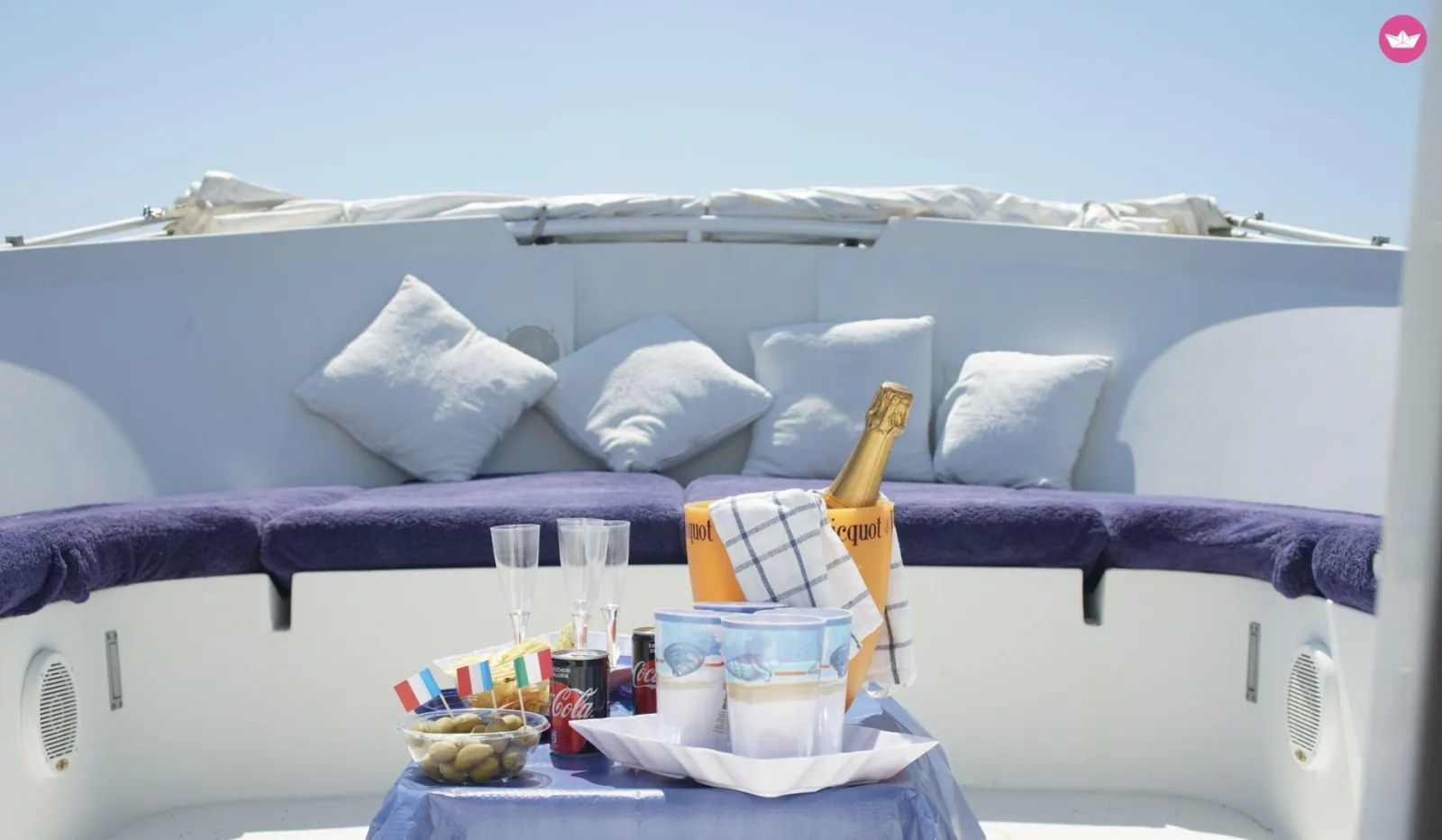 The yacht's cushioned foredeck set with an aperitif and chilled sparkling wine
