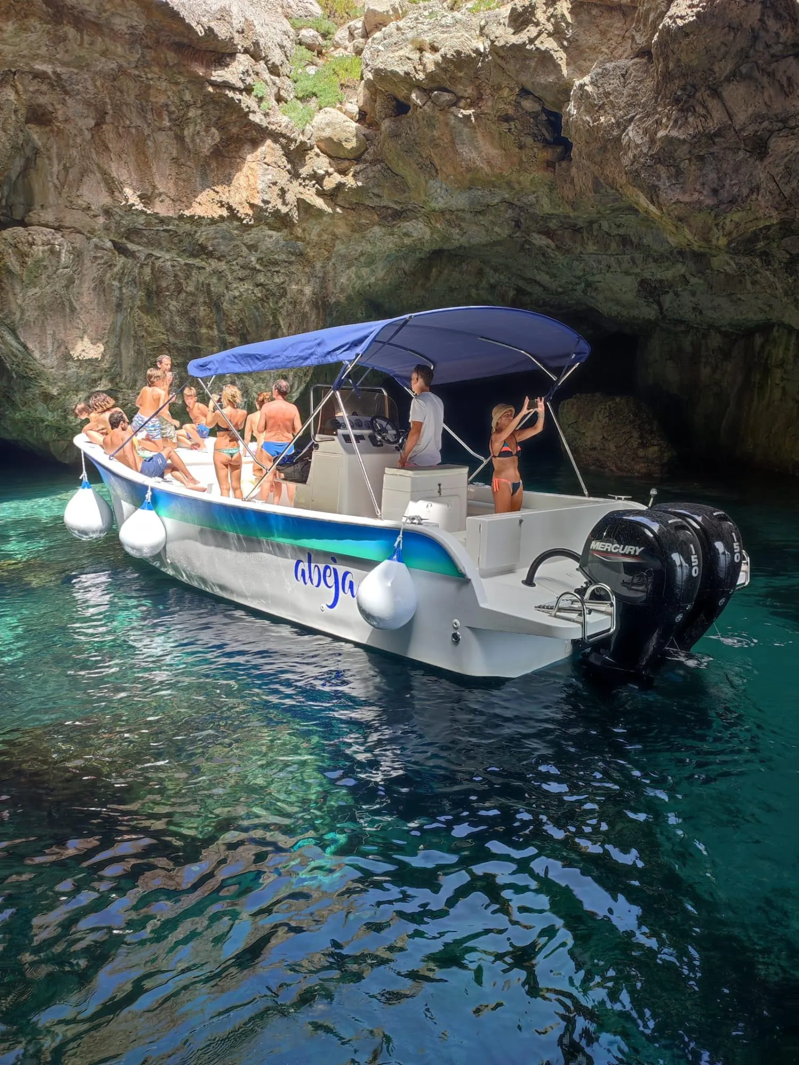 The boat moored inside a sea cave on the Favignana coast