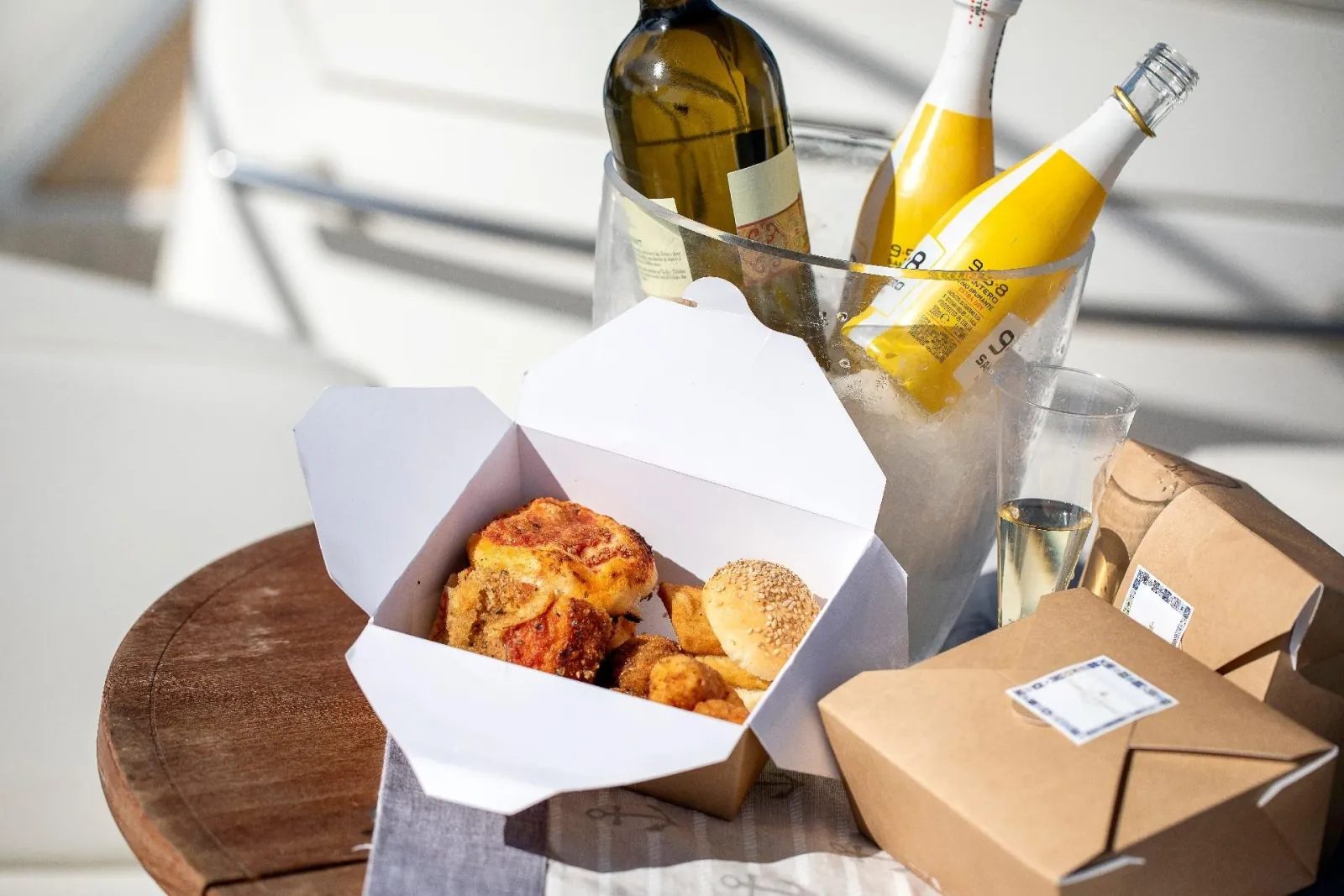 A boxed Sicilian lunch and chilled wine set out on board