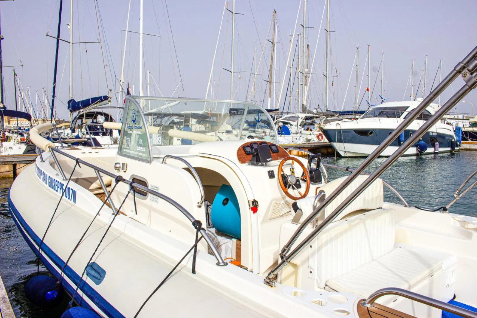A motorboat berthed among yachts in Trapani marina before departure