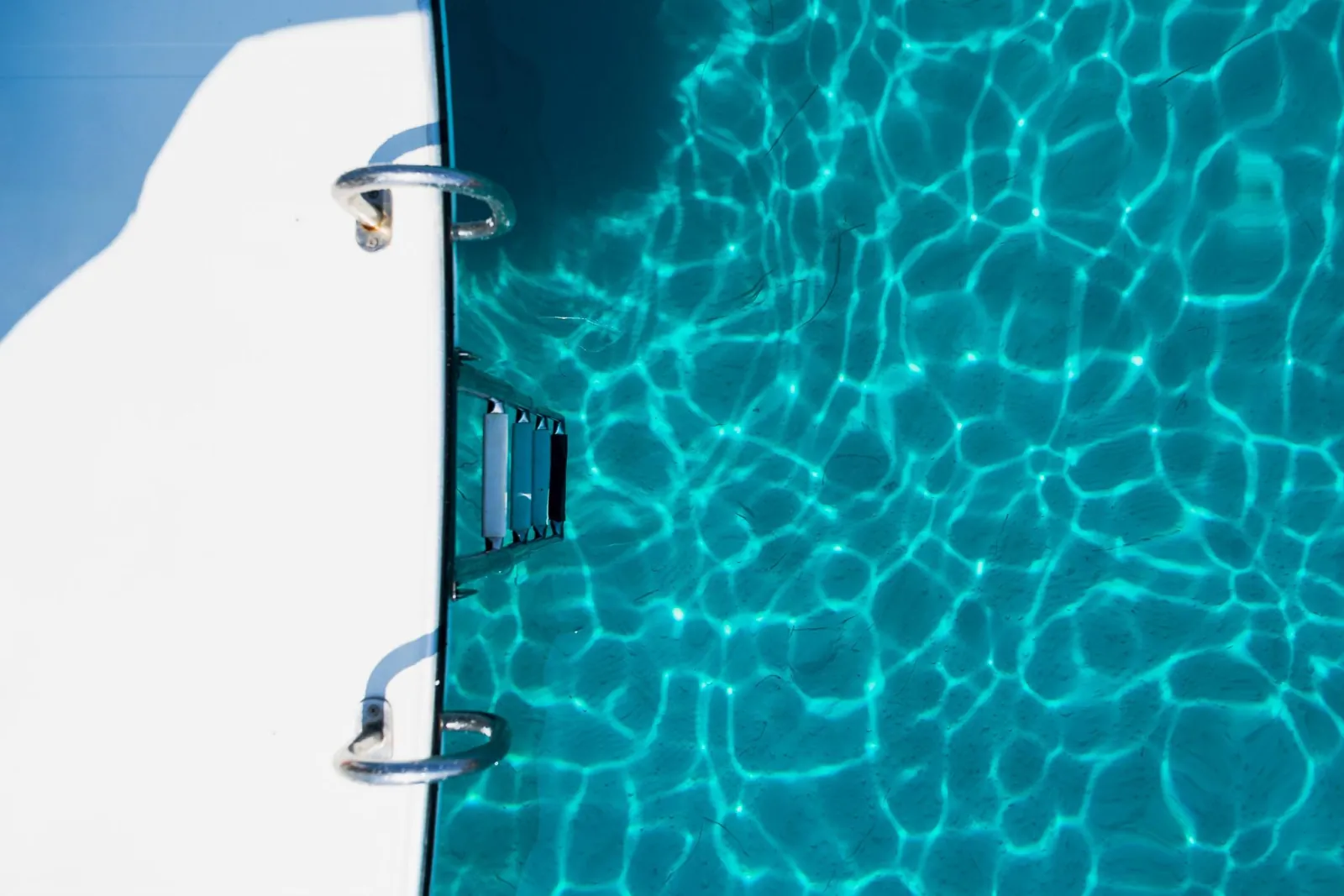 The boarding ladder over bright turquoise water at a swim stop